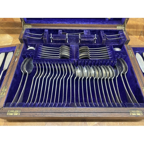 114 - Oak cased table top canteen of silver plated cutlery, the hinged lid enclosing two further hinged pa... 