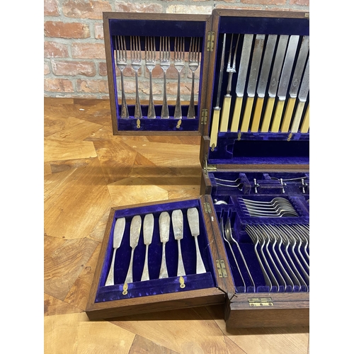 114 - Oak cased table top canteen of silver plated cutlery, the hinged lid enclosing two further hinged pa... 