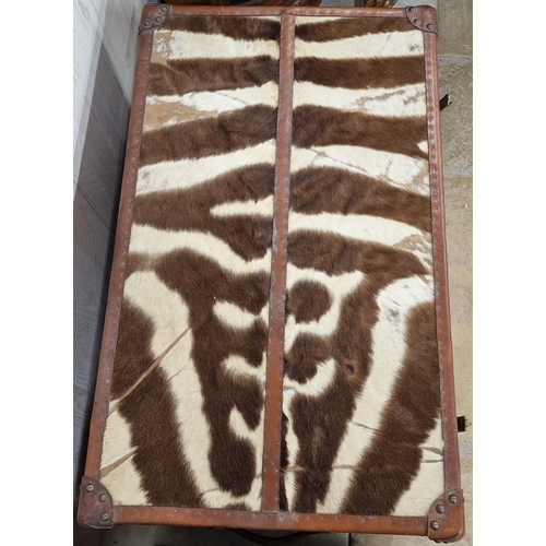 1231 - Pair of good quality reclaimed tan leather and zebra hide trunks, with brass fittings and twin leath... 