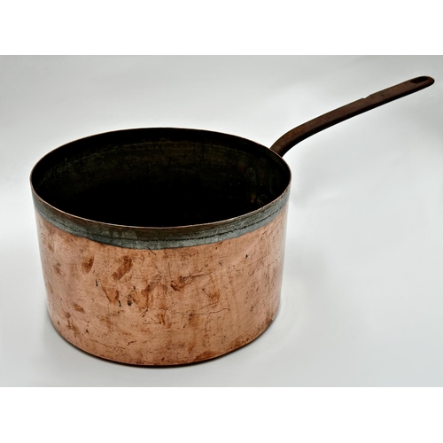 601 - A large copper saucepan with iron handle, 61cm L in total