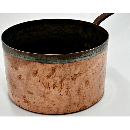 601 - A large copper saucepan with iron handle, 61cm L in total