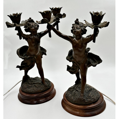 1163 - A pair of French figural spelter twin branch table lamps in the form of cherubs, the sconces are bei... 