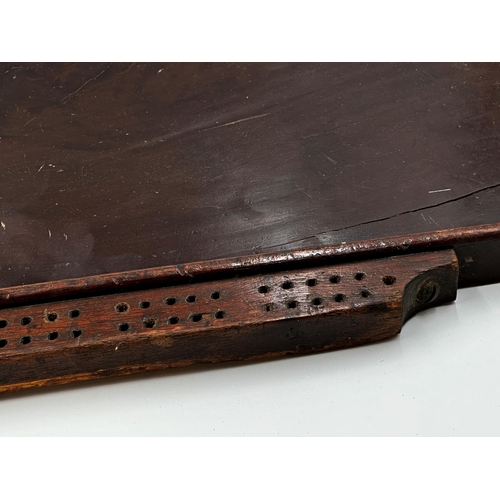 555 - Antique plum pudding mahogany games board with markers to either side, 56cm x 52cm.