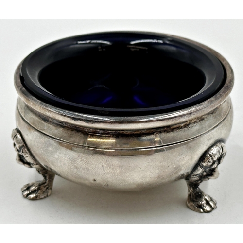 207 - American silver circular salt, with cast lion head feet and blue glass liner, circa 1910, 7cm diamet... 