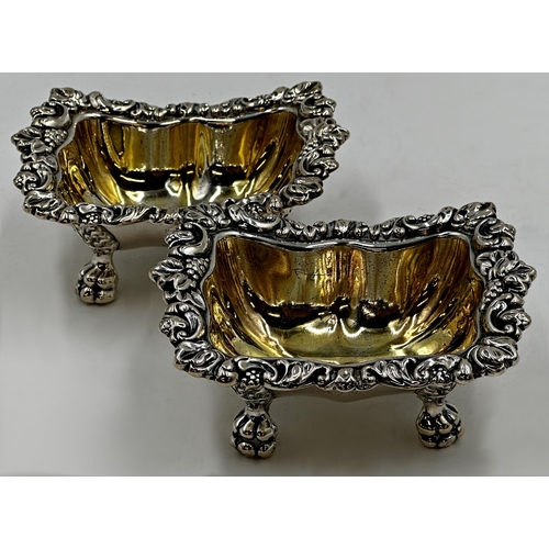 208 - Good pair of William IV cast silver table salts, with scrolled borders, paw feet and gilt interiors,... 