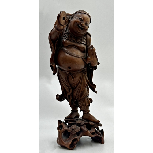 503 - Carved Japanese hardwood figure of a rotund dancing gentleman holding a lizard in one hand and a tok... 