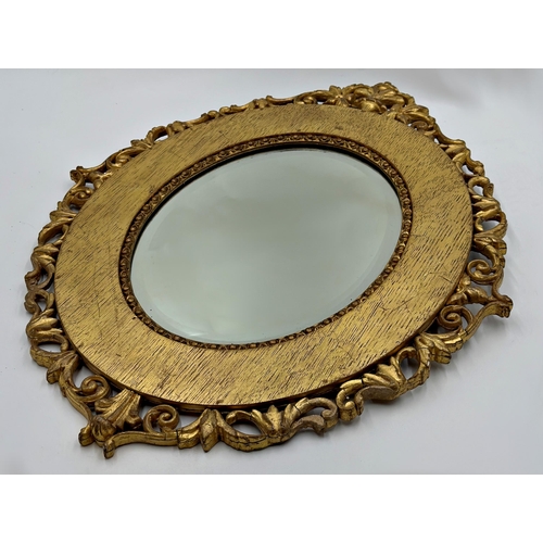 1137 - A pair of Antique Florentine style giltwood framed oval wall mirrors with bevelled glass plate, 56cm... 