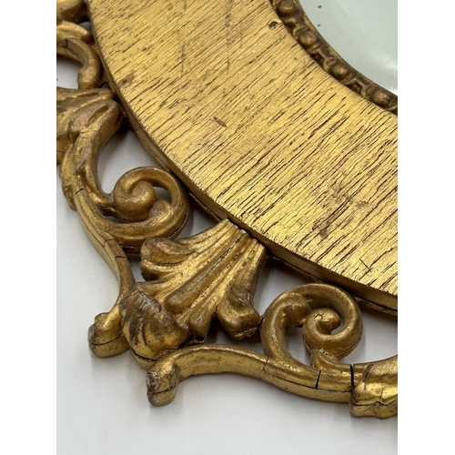 1137 - A pair of Antique Florentine style giltwood framed oval wall mirrors with bevelled glass plate, 56cm... 