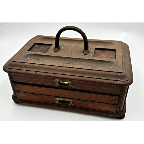 575 - A late 19th century campaign style oak desk standish the top with two pen trays and two recessed hol... 