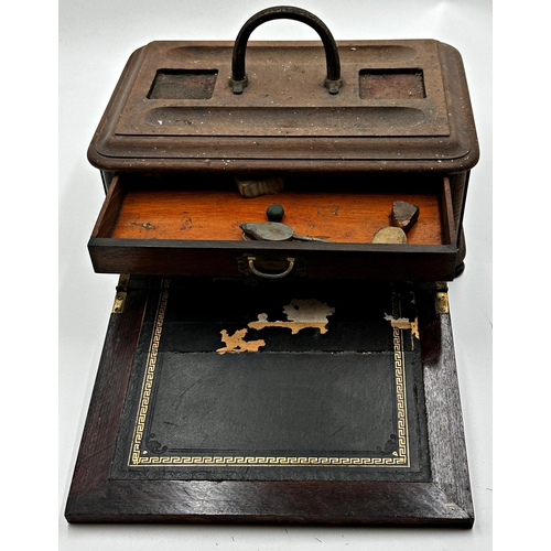 575 - A late 19th century campaign style oak desk standish the top with two pen trays and two recessed hol... 