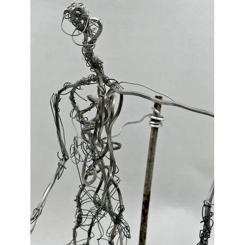 1254 - Unusual figural wirework sculpture upon a plinth base, 53cm high.