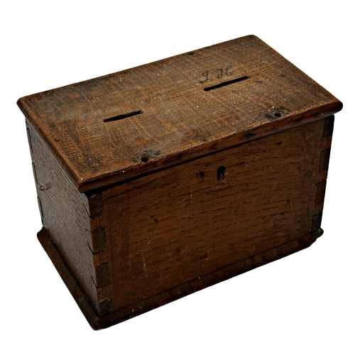 579 - 19th century primitive oak collection box the hinged lid with two holes for coins, containing large ... 