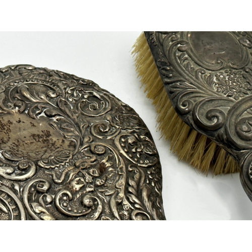 287 - Two antique silver applied hand mirrors with a further dressing brush (3)