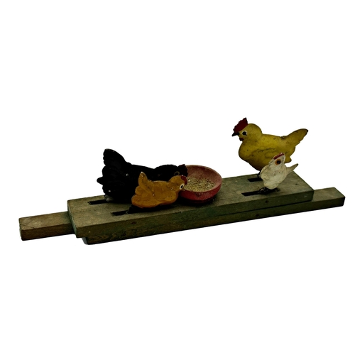 392 - A wooden and metal pull along toy of chickens pecking grain together with a further metal stamp box ... 