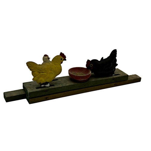 392 - A wooden and metal pull along toy of chickens pecking grain together with a further metal stamp box ... 