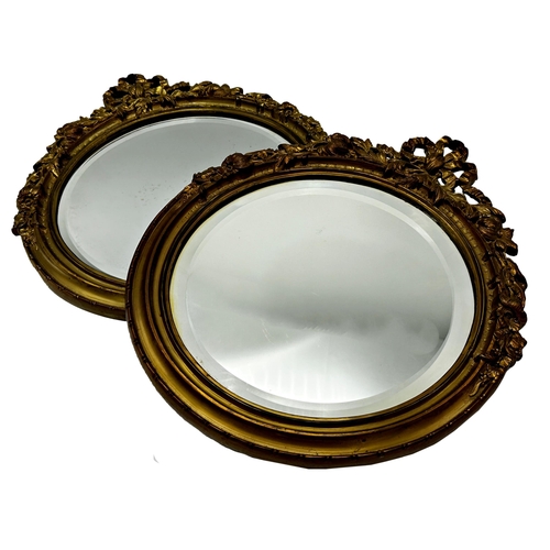 1141 - Pair of continental ormolu framed tondo wall mirrors with original bevelled glass mounted by a tied ... 