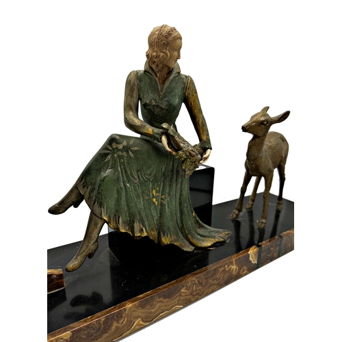 75 - Art Deco French black slate figural mantel clock mounted by a seated female and deer, with two train... 