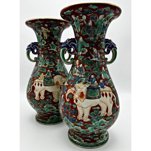 492 - Pair of twin handled Chinese porcelain vases, enamelled in relief with elephants. 30cm high