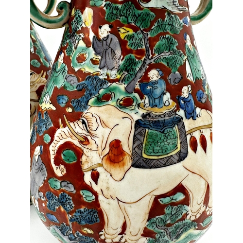 492 - Pair of twin handled Chinese porcelain vases, enamelled in relief with elephants. 30cm high