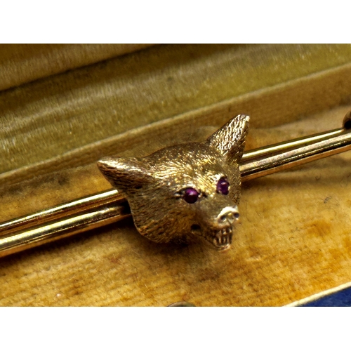 103 - Good 9ct fox head and riding crop tie pin or bar brooch, with ruby set eyes, 6.4cm long, 7.2g