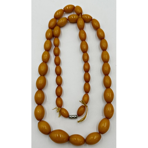 128 - String of graduated amber or amber coloured beads, 88cm long, 95.1g gross