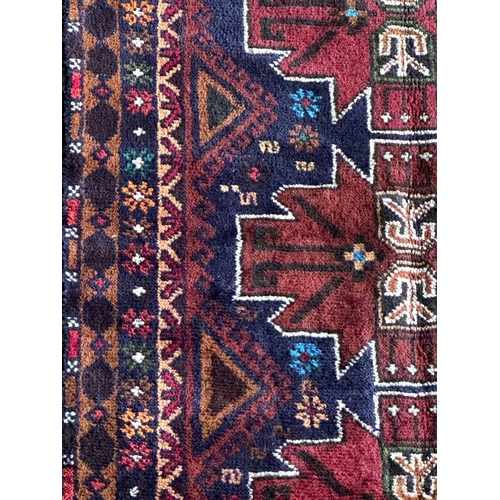 1578 - Good Afghan rug, three red medallions on a navy blue ground, L153 x W87cm