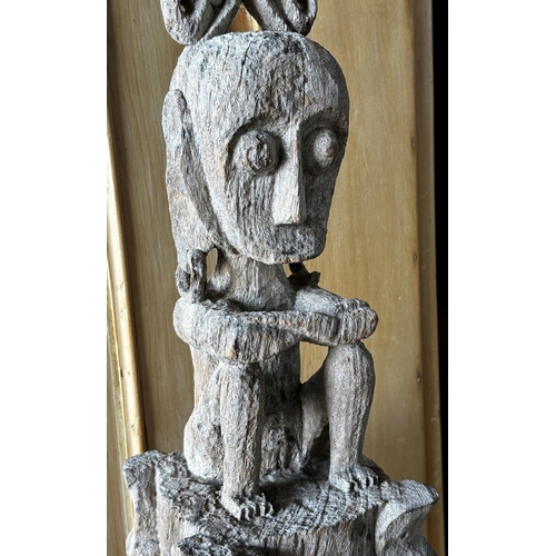 517 - Tribal interest- Carved hardwood tiki type pole mounted by a seated tribesman, 126cm high