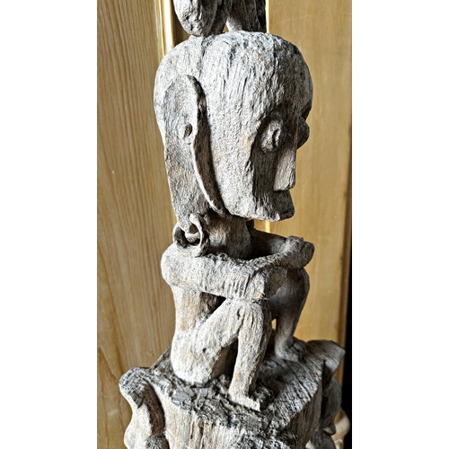 517 - Tribal interest- Carved hardwood tiki type pole mounted by a seated tribesman, 126cm high