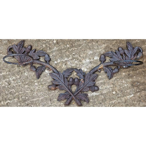 1064 - Cast iron wall hanging pot stand with acorn and leaf detail, 71cm wide