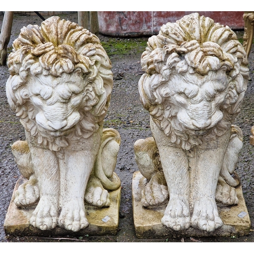 1067 - Pair of reconstituted stone garden ornaments in the form of seated lions, 42cm high