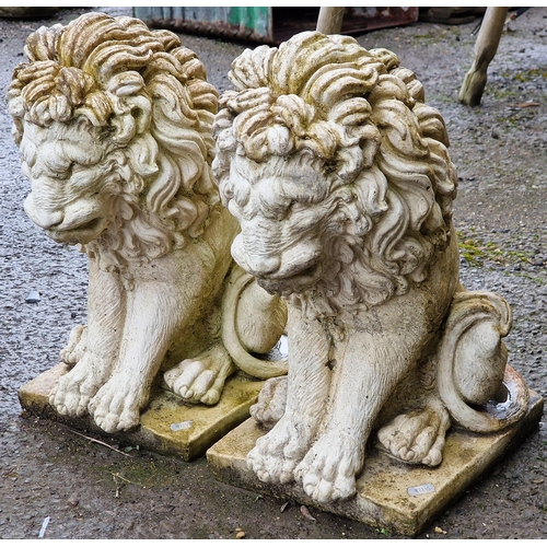 1067 - Pair of reconstituted stone garden ornaments in the form of seated lions, 42cm high