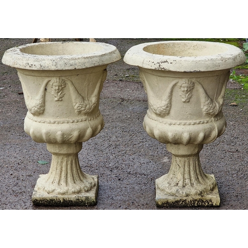 1078 - Pair of reconstituted buff coloured stone garden urns with cherub mask and swag detail, 54cm high