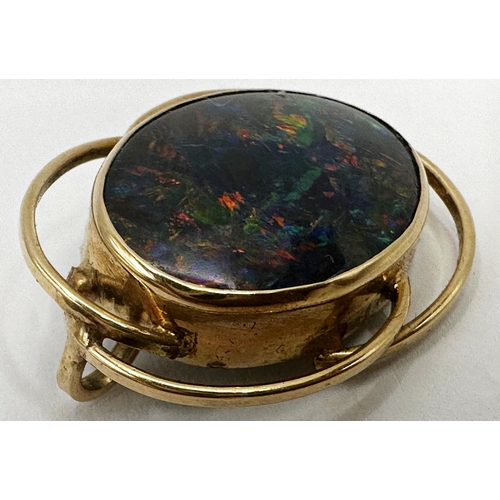 179 - Mid 20th century yellow metal black opal brooch in scrolled mount, the stone 20 x 15mm, 3cm high in ... 