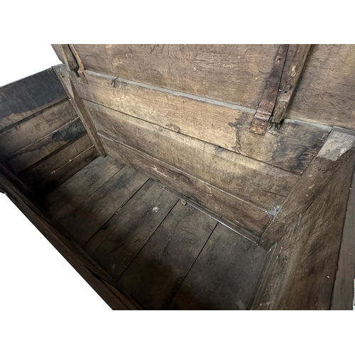 1334 - Early large pegged oak coffer, with various shaped panels upon a primitive plinth base, 90cm high x ... 