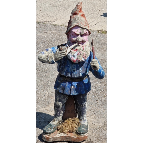 1115 - A reconstituted stone garden statue of a gnome smoking a pipe with distressed painted finish, 88cm h... 