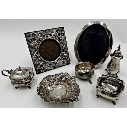 313 - Mixed silver comprising three piece cruet, further salt, small dish and two easel frames (7)