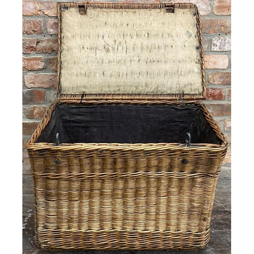 1328 - Early 20th century large wicker hamper, hinged lid enclosing a linen lined interior upon castors, 51... 