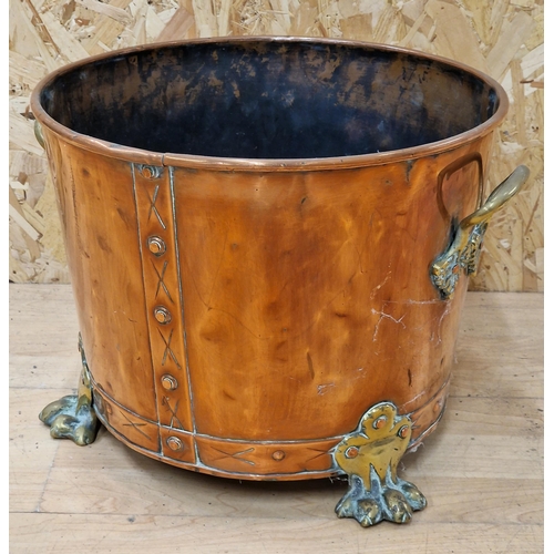 656 - Good antique copper and twin brass handled log bucket upon rivetted brass paw feet, 29cm high