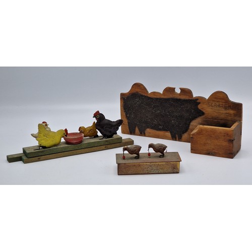 392 - A wooden and metal pull along toy of chickens pecking grain together with a further metal stamp box ... 