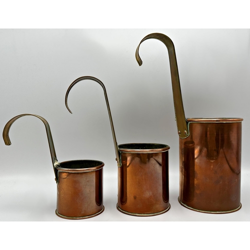 309 - Three 19th century copper and brass measures for 2pint, pint and half pint. The largest 27.5cm high ... 