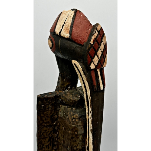 212 - Tribal interest- carved wooden figure of a standing bird with applied brass decoration 46cm high