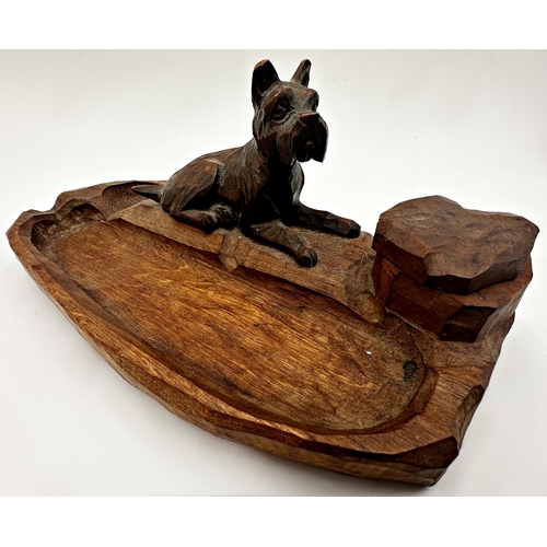 284 - Black Forest style carved wooden desk standish mounted by a recumbent terrier, with revolving top ce... 