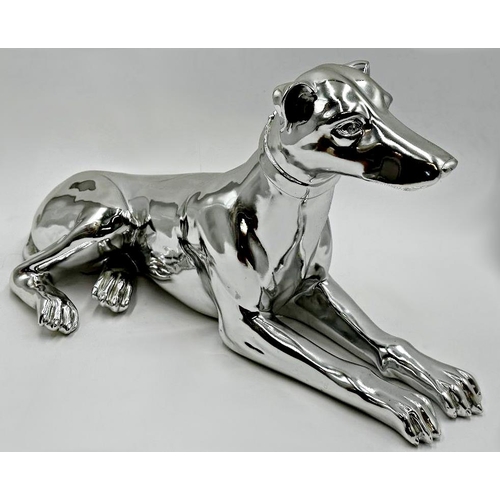 399 - Silvered resin model of a recumbent greyhound, 52cm long