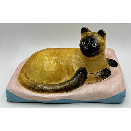 407 - Two large papier mache cats, a Siamese on a cushion, 26cm H x 41cm W, and a seated tabby 37cm high (... 