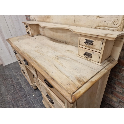 2410 - Victorian pine dresser with shaped back fitted with an arrangement of eleven drawers and central cup... 