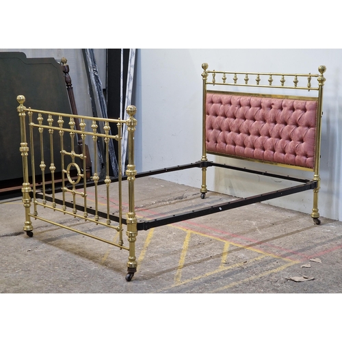 2425 - Victorian brass bedstead with iron side rails, cushioned headboard and studded edging raised on cera... 