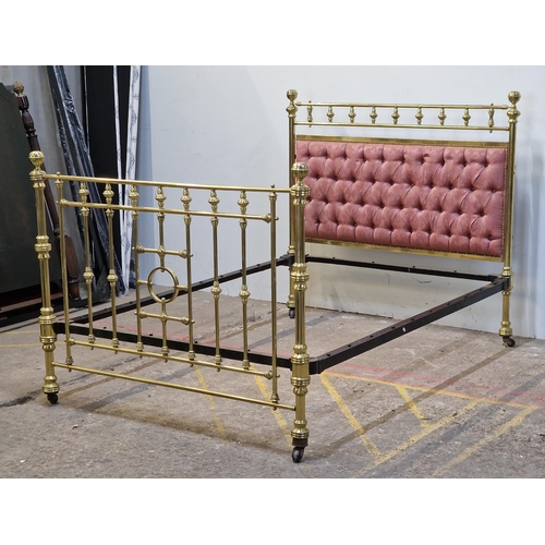 2425 - Victorian brass bedstead with iron side rails, cushioned headboard and studded edging raised on cera... 