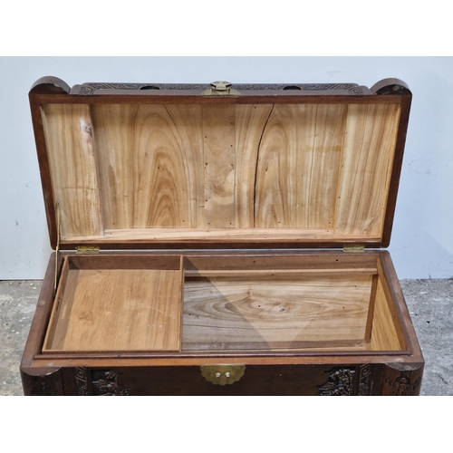 2427 - Oriental carved camphor wood blanket box with brass hinged lock, H 56cm x W 101cm x D 54cm