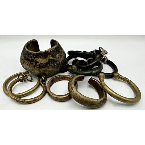 228 - Set of five African bronze Manilla currency bangles, 6.5cm wide, together with a further large engra... 