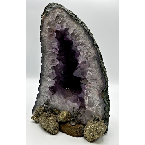 409 - An amethyst and pyrite geode with applied fools gold mining figures, 26cm high x 16cm wide